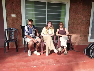 a group of three people sitting on a porch at Kannur west beach homestay in Kannur