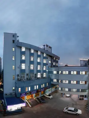 a large building with cars parked in a parking lot at Sri Aarvee Hotels in Coimbatore