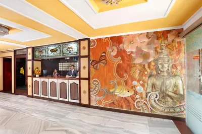 a lobby with a wall mural of a buddha at Sri Aarvee Hotels in Coimbatore