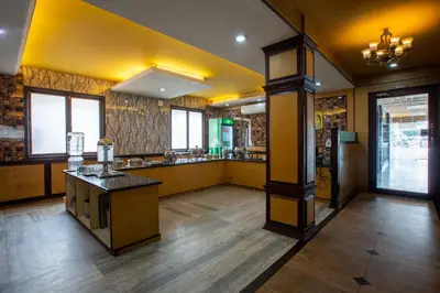 a large room with a kitchen with yellow ceilings at Sri Aarvee Hotels in Coimbatore