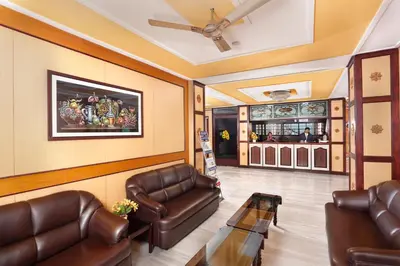 a waiting room with leather chairs and a bar at Sri Aarvee Hotels in Coimbatore