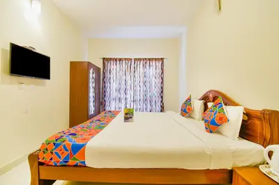a bedroom with a large bed with a television on the wall at FabHotel Vinu Valley Resorts - Nr Ketti Valley View Point in Ooty