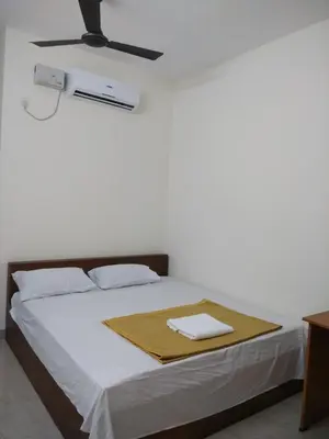 a bedroom with a bed with a towel on it at Manjira Lodge in Guruvāyūr
