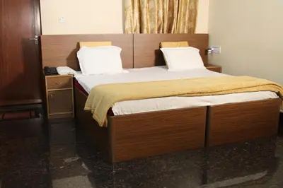 a bedroom with a large bed with a wooden headboard at ShivalayaHomestay in Trichūr