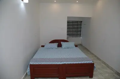 a bedroom with a bed in a room with a window at Thekkumpuram Tourist Home in Malappuram