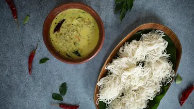 a bowl of soup and noodles on a table at Raindrops Resorts Wayanad in Sultan Bathery