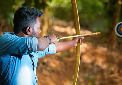 a man aiming a bow and arrow in a target at Raindrops Resorts Wayanad in Sultan Bathery