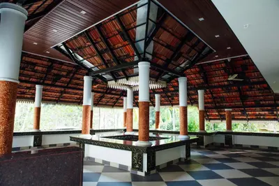 a large building with a roof with columns and a tiled floor at Mi Casa Tu Casa Homestay in Cochin