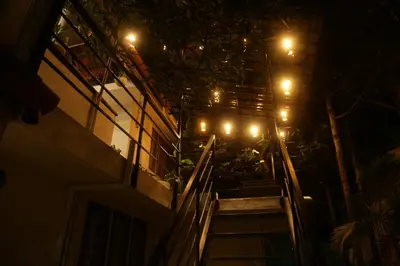 a set of stairs leading up to a building at night at Mi Casa Tu Casa Homestay in Cochin