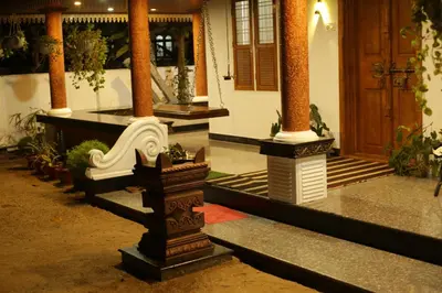 a building with columns and plants in a courtyard at Mi Casa Tu Casa Homestay in Cochin