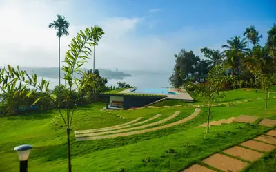 a park with a building and a field of grass at LakeRose Wayanad Resort in Ambalavayal