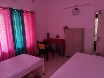 a room with colorful curtains and a table and a desk at Takashi Homestay North Paravur Near Muziris in North Paravur