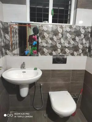 a bathroom with a sink and a toilet and a mirror at Takashi Homestay North Paravur Near Muziris in North Paravur