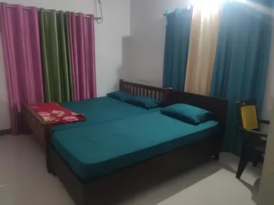 a bed in a room with colorful curtains at Takashi Homestay North Paravur Near Muziris in North Paravur