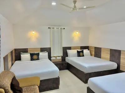 a hotel room with two beds and a couch at Riyavar Luxury Stay in Siddapur