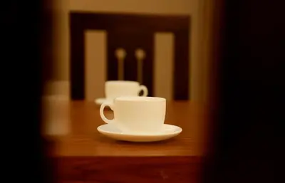 two cups and a saucer on a table at Wayanad Royal Crown in Kalpetta