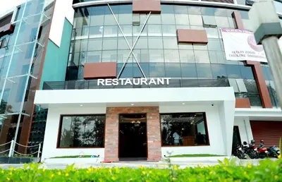 a building with a sign that reads restaurant at Wayanad Royal Crown in Kalpetta