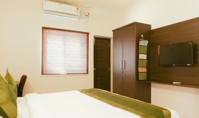 a bedroom with a bed and a flat screen tv at Treebo Hi Line Apartments Kalapatti in Coimbatore