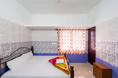 a small bedroom with a bed and a window at Sri Nandha Luxury Comforts in Vālpārai