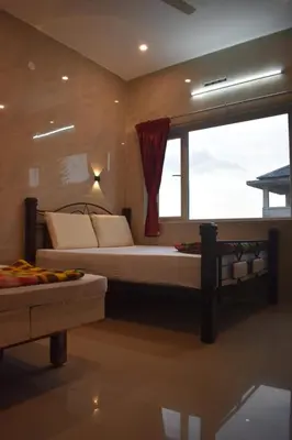 a bedroom with a bed and a large window at Sri Nandha Luxury Comforts in Vālpārai