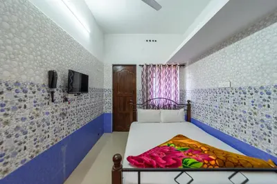 a bedroom with a bed in a room with blue and white tiles at Sri Nandha Luxury Comforts in Vālpārai