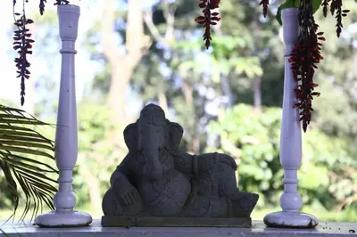 a stone statue between two vases on a table at Coorg Kolamotte in Gonikoppal