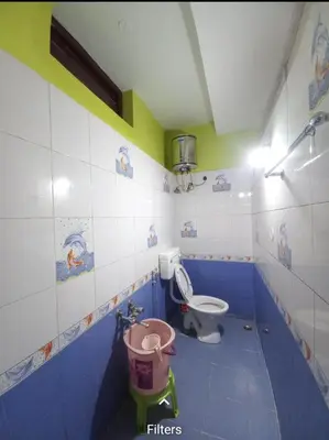 a bathroom with a toilet and a bucket in it at smile stone individual cottage in Ooty