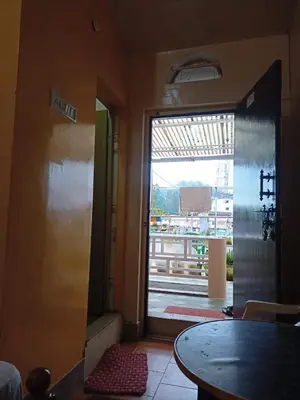 a door to a room with a view of a building at Hill Inn Rooms an HomeStay in Ooty