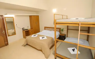 a room with two bunk beds and a mirror at Nandanam Villa in Kaniyāmbetta