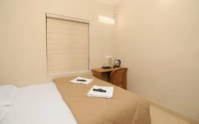 a bedroom with a bed and a table with towels at Nandanam Villa in Kaniyāmbetta