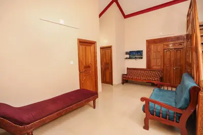 a living room with a couch and a chair at Nandanam Villa in Kaniyāmbetta