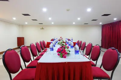 a long table in a room with red chairs at Trichur Towers in Trichūr