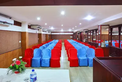 a conference room with red and blue chairs and a table at Trichur Towers in Trichūr