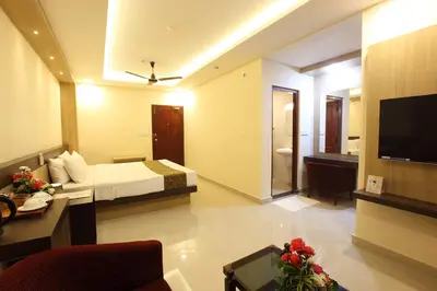 a hotel room with a bed and a television at Trichur Towers in Trichūr