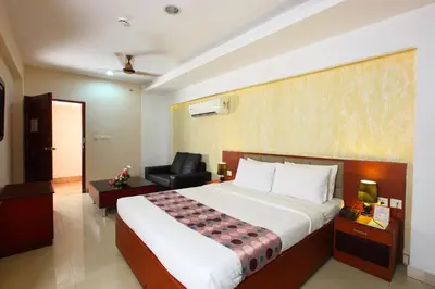 a hotel room with a bed and a chair at Trichur Towers in Trichūr
