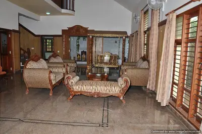 a living room with several couches and a mirror at Suvarna Luxury Home Stay in Mysore
