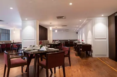 a dining room with tables and chairs in a restaurant at Southern Star,Mysore in Mysore