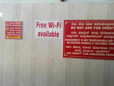 a sign on a wall that says free wifi available at vrs dormitary in Mysore