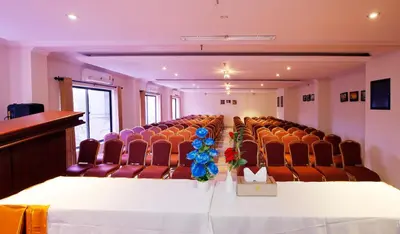 a room with chairs and a table with flowers on it at Rose International Hotel in Nilambūr