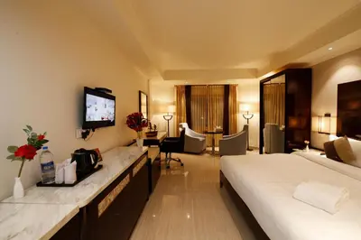 a hotel room with a bed and a television at Hotel Park Residency in Nilambūr