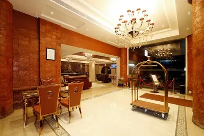 a lobby with a table and chairs and a chandelier at Hotel Park Residency in Nilambūr