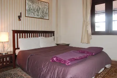 a bedroom with a bed with purple sheets and a window at Colonial 4 B/R Home, Great for Families, Coonoor in Coonoor