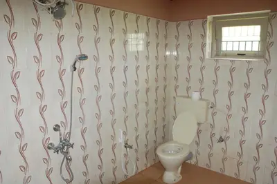 a bathroom with a toilet and a shower at Relaxing 2 B/R Estate House, Deenaty, Tamil Nadu in Coimbatore