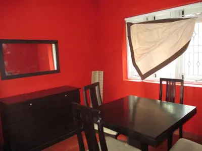 a dining room with a wooden table and a window at Relaxing 2 B/R Estate House, Deenaty, Tamil Nadu in Coimbatore