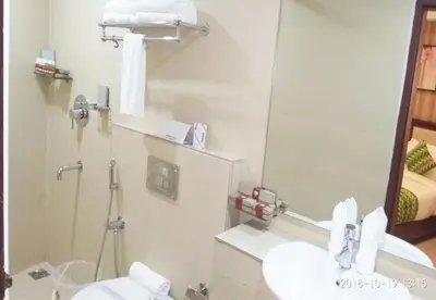 a bathroom with a sink and a mirror at Queens Hotel in Kozhikode