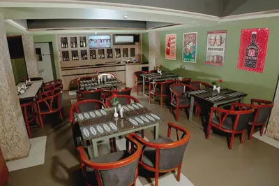 a restaurant with tables and chairs in a room at Queens Hotel in Kozhikode