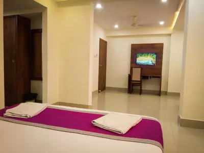two towels sitting on a bed in a room at Nexstay Crystal Residency in Kozhikode