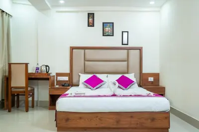 a bedroom with a bed with purple pillows and a desk at Nexstay Crystal Residency in Kozhikode