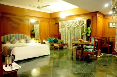 a bedroom with a bed and a table and chairs at Sandesh The Prince in Mysore