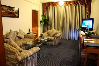 a living room with two couches and a television at Sandesh The Prince in Mysore